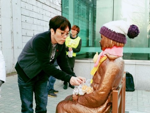 日本領事館の前に設置された少女像を訪れた市民が手袋を置いている。