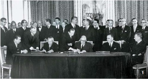 １９６３年１月２２日、仏エリゼ宮でアデナウアー西ドイツ首相（正面を向いて座っている人のうち左側）とドゴール仏大統領（真ん中）が両国の友好条約に署名している姿を、ポンピドゥー仏首相（右）が眺めている。