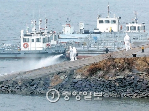 ５日、漢江の渡船場（ソウル城東区）で区庁職員が鳥インフルエンザの防疫作業を行っている。
