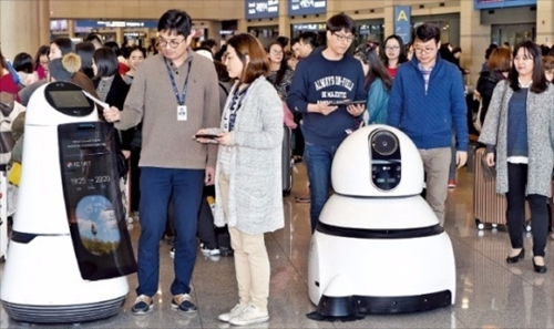ＬＧエレクトロニクスの研究員が仁川国際空港入国フロアで案内ロボット（左）と清掃ロボットをテストしている。