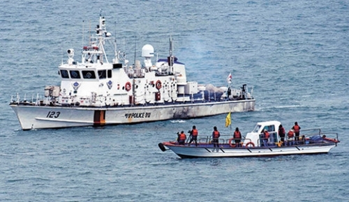 「セウォル号惨事家族協議会」の旗をつけた船が引き揚げ試験作業が進行中の東巨次島沖に近づくと、警備艦が阻止した。（写真＝共同取材団）