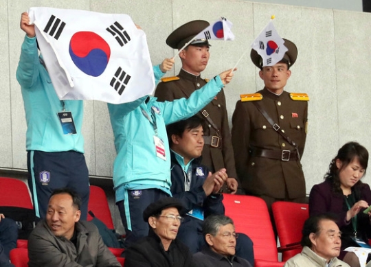 後半３１分、韓国の同点ゴールが決まり、太極旗（韓国の国旗）を持って喜ぶサッカー協会関係者（平壌＝写真共同取材団）