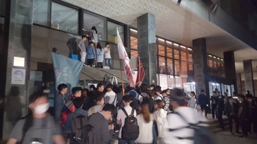 １日午後８時、学生らがソウル大行政館を再占拠するためにガラス窓を破って２階に進入しようとしている。