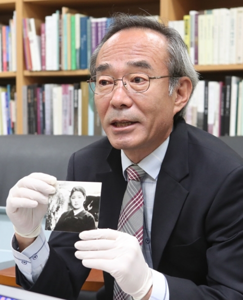 日本人から寄贈された釜山出身の慰安婦の写真を見せているキム・ウリム館長。
