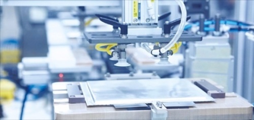 忠南瑞山市ＳＫイノベーション電気車バッテリー工場でロボットが銀色のパウチで包装されたバッテリーセルをパック工程に移送するために準備中だ。（写真＝ＳＫイノベーション）