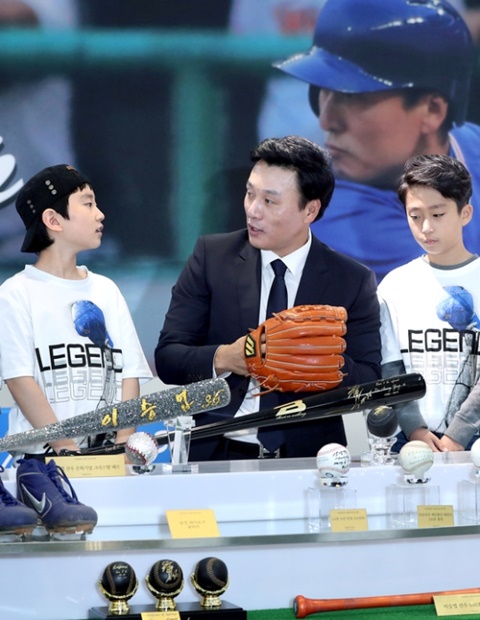 １５日、ソウル龍山の大型ショッピングセンター「Ｉ’ＰＡＲＫ　ｍａｌｌ」で開かれた引退記念展の開幕イベントに出席した李選手が子どものファンと話をしている。