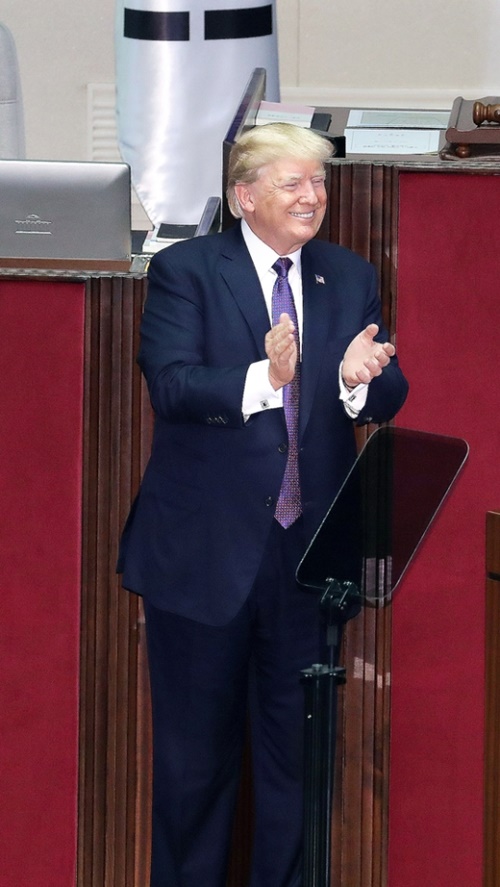 韓国の議員らと共に拍手するトランプ大統領。