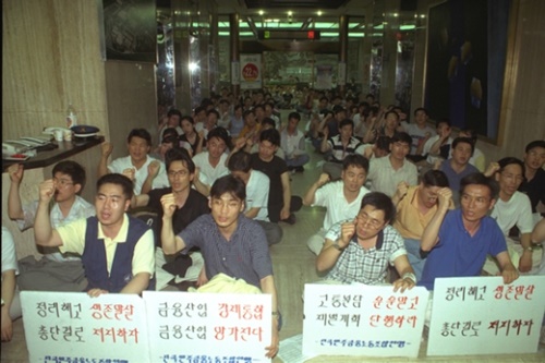 新韓銀行が買収することに決まったソウル・積善洞の同和銀行本店に金融監督院の調査チームが到着すると労組員が出入りを阻止している。