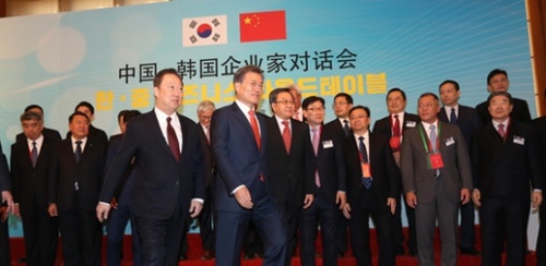 文在寅大統領（前列左から７人目）と朴容晩（パク・ヨンマン）大韓商工会議所会長（前列左から６人目）が韓中の企業家と記念撮影をしている。（写真提供＝大韓商工会議所）