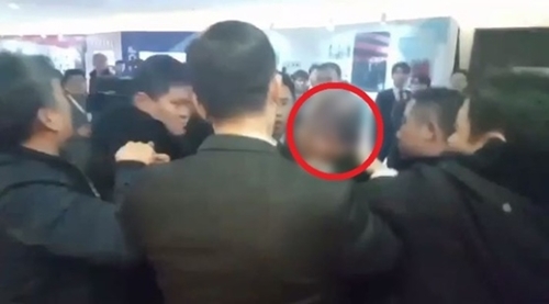 中国で取材中に暴行を受ける韓国人記者（赤丸）。（写真＝中央フォト）