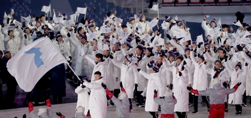 南北選手が９日、平昌オリンピックスタジアムで開かれた２０１８年平昌冬季五輪開会式で韓半島の旗を持って入場している。（写真＝共同取材団）