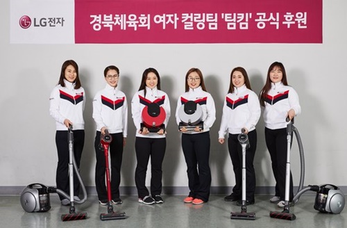 女子カーリングチーム代表チームが７日、ＬＧ掃除機「コードゼロ」の広告撮影現場で製品を持ってポーズを取っている。（写真＝ＬＧエレクトロニクス）