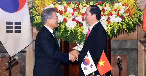 韓国の文在寅大統領とベトナムのチャン・ダイ・クアン国家主席が23日午前(現地時間)、会談場であるハノイ主席宮で開かれた共同記者会見終了後、両手を取り合っている。（写真＝青瓦台写真記者団）