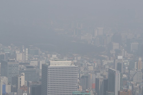 ２５日午前、ソウル南山から見た都心が粒子状物質で灰色に濁っている。