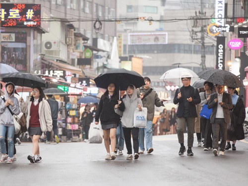 相合傘で歩きながらどんなお店に入ろうか相談する学生たち。雨天でもショッピングは楽しみたいものですね。