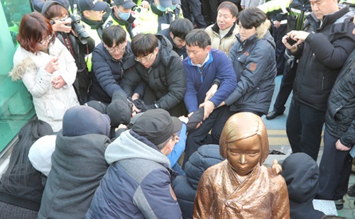 ２０１６年１２月、釜山の日本領事館前で少女像設置推進市民団体のデモ参加者が釜山東区庁撤去班員らに抵抗している。
