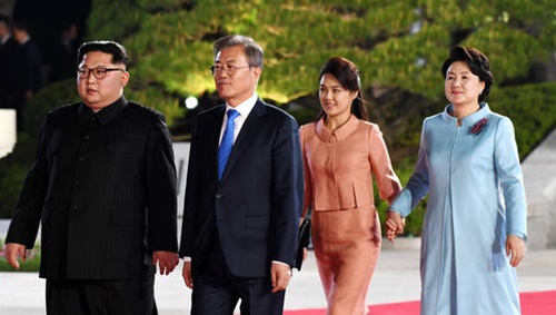 ２０１８南北首脳会談が開催された２７日、板門店で文在寅（ムン・ジェイン）大統領と金正恩（キム・ジョンウン）国務委員長（左）、金正淑（キム・ジョンスク）夫人（右）、李雪主（イ・ソルジュ）夫人が公演会場に向かって並んで歩いている。（韓国共同写真記者団）