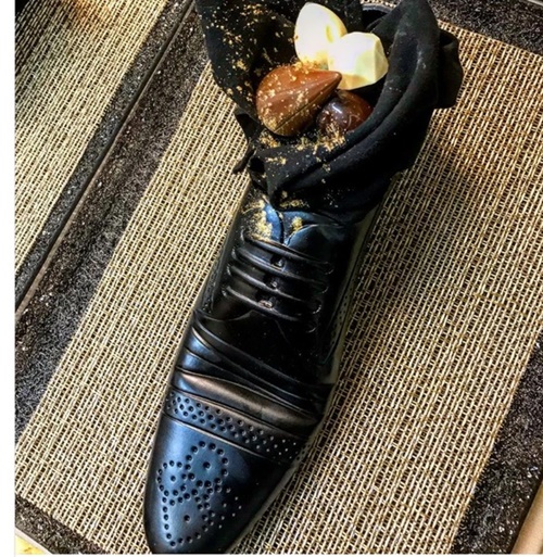 ２日、安倍首相夫妻とイスラエルのネタニヤフ首相夫妻の夕食会に登場した「靴のデザート」。男性の靴の形をした食器に各国のチョコレートが入っている。（セゲブ・モシェ氏のインスタグラム）