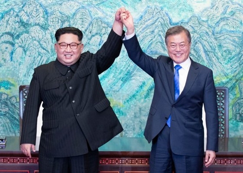 韓国の文在寅大統領（左）と北朝鮮の金正恩国務委員長が４月２７日午後、板門店の「平和の家」で開かれた南北首脳会談で、韓半島の平和と繁栄、統一のための板門店宣言文に署名した後、手を握っている。