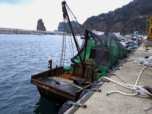 ２０１４年に鬱陵島（ウルルンド）沖で漂流しているところを韓国海軍に発見された北朝鮮船が鬱陵島の港に曳航されている。この漁船は長さ１４メートル、幅３．２メートル、高さ５メートルの１５トン級で、見つかった当時は船員がいなかった。（写真提供＝慶北日報]