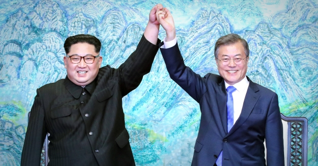 韓国の文在寅（ムン・ジェイン）大統領（右）と北朝鮮の金正恩（キム・ジョンウン）国務委員長が４月２７日午後、板門店「平和の家」で開かれた南北首脳会談で、韓半島の平和と繁栄、統一のための板門店宣言文に署名した後、お互い手を握ってあげている。（青瓦台写真記者団）