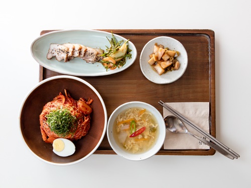 現地韓国人に人気なのが「舞月食卓」の「バーベキュービビンクッス(10,500ウォン)」。ジューシーなポッサムと辛口混ぜ麺の相性はGOOD！