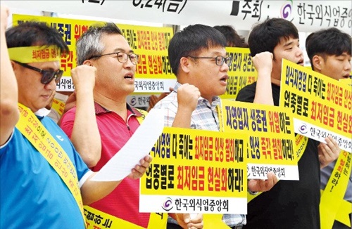 韓国外食業中央会の主催で２０日にソウルの光化門広場で「最低賃金引き上げ糾弾集会」が開かれた。集会に参加した自営業者が急激な最低賃金引き上げを批判し制度改善を促すスローガンを叫んでいる。