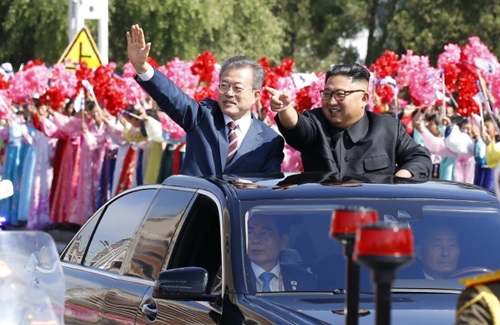 文在寅大統領と金正恩国務委員長が１８日、平壌順安空港から百花園招待所に移動する車で市民にあいさつしている。（平壌写真共同取材団）