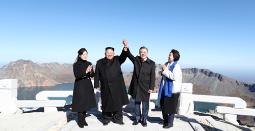平壌首脳会談３日目の２０日午前、韓国の文在寅大統領と北朝鮮の金正恩国務委員長が白頭山頂上である将軍峰に登って取り合った手を高く上げている。