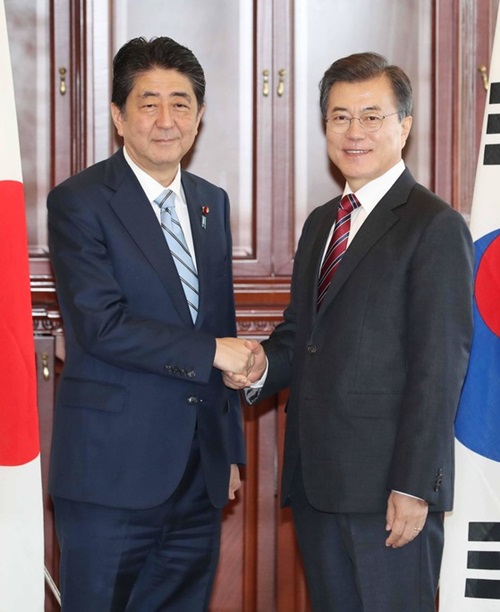 韓国の文在寅大統領が昨年９月７日、ロシア・ウラジオストク極東連邦大学で日本の安倍晋三首相と韓日首脳会談前に握手している。（写真＝中央フォト）
