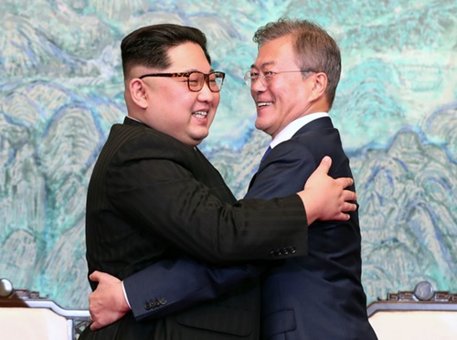 韓国の文在寅大統領（右）と北朝鮮の金正恩国務委員長が、４月２７日の南北首脳会談で「板門店宣言文」に署名後、明るい笑顔で抱擁している。（写真＝青瓦台写真記者団）