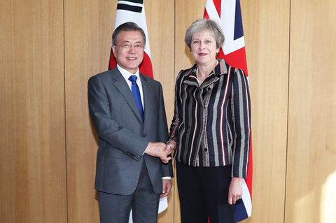 英国のメイ首相と握手する文在寅大統領（写真＝青瓦台写真記者団）
