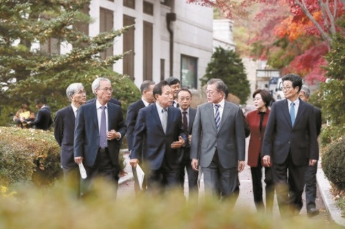 文在寅大統領が２１日午後、青瓦台で国政課題推進委員会および大統領諮問機構委員と昼食懇談会を終えた後、出席者と共に散歩している。前列左から文成賢（ムン・ソンヒョン）経済社会労働委員会委員長、金広斗（キム・グァンドゥ）国民経済諮問会議副議長、文大統領、李穆熙（イ・モクヒ）雇用委員会副委員長。（写真＝青瓦台写真記者団）