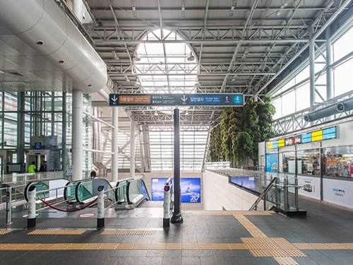 駅構内入ってすぐにある下りのエスカレーターで、地下２階が直通列車の改札口、地下３階が一般列車の改札口です。