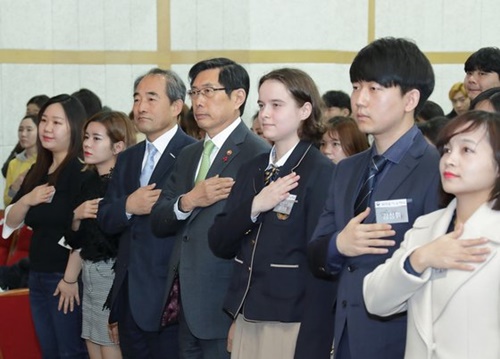 朴相基（パク・サンギ）法務部長官（中央）が先月２１日、ソウル龍山区（ヨンサング）国立ハングル博物館大講堂で開かれた第１回大韓民国国籍証書授与式で国旗に対し敬礼をしている。
