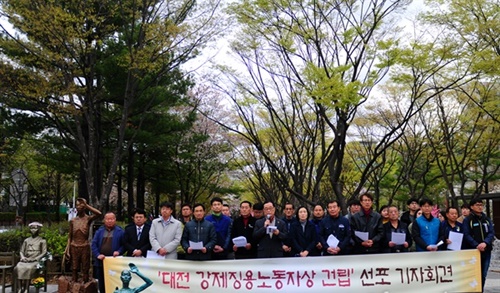 釜山の強制徴用労働者像。市民団体のメンバーが記念写真を撮影している。