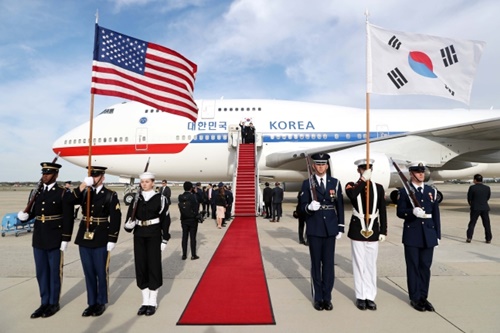 韓国の文在寅大統領が韓米首脳会談のために１１日午前（現地時間）、米国アンドルーズ空軍基地空港に到着して挨拶をしている。写真右上の儀仗隊の太極旗の青色の部分が空色になっている。