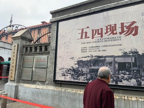 五・四運動の発源地、北京大学旧建物（現在は北京新文化運動記念館）で開かれている五・四運動記念展示会入口で、北京のある市民が広報の張り紙を見ている。