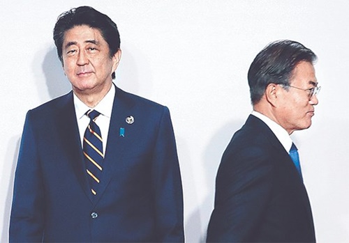 文在寅（ムン・ジェイン）大統領（右）が２８日、大阪で開催されたＧ２０首脳会議の歓迎式で安倍首相（左）と８秒間握手した後、移動している。（写真＝青瓦台写真記者団）