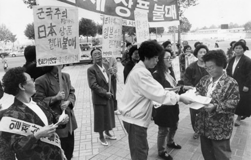 １９９２年、ソウル蚕室のロッテ百貨店前で行われた日本製品不買運動集会。当時ロッテ百貨店１０階で開かれた「新潟観光物産展示会」を糾弾した。日本の商品を燃やした後、市民に関連印刷物を配った。（中央フォト）