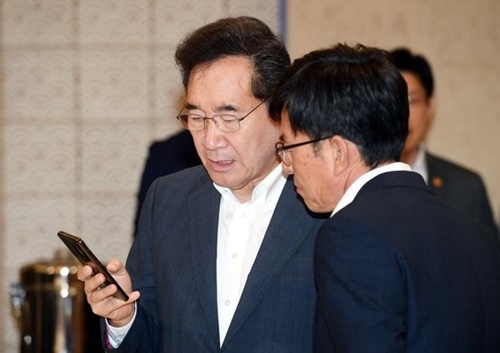 韓国の李洛淵首相（左）と青瓦台の金尚祖・政策室長（右）が今月２日午前、青瓦台で開かれた国務会議の開始前に話をしている。［写真　青瓦台写真記者団］