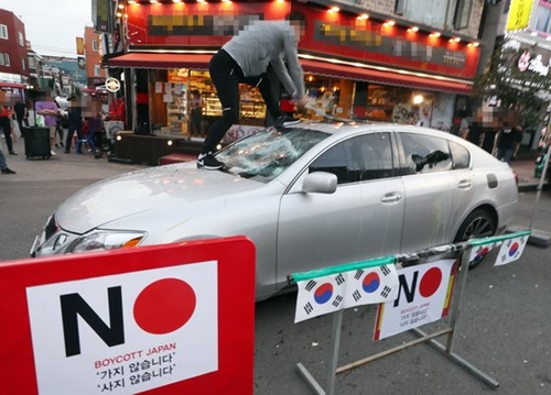 仁川市南洞区で行われた「日本経済報復糾弾不買運動宣言行事」で日本車レクサスをたたきつぶす市民［中央フォト］