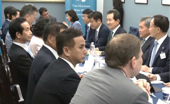 先月２６日にワシントンで開かれた韓日米議員会議で固い表情で座る自民党の山本幸三衆議院議員（左）と向かい合う丁世均前国会議長（右上）。丁元議長は「日本との水面下での接触で当面の成果はなかったが議員間の会合は続くだろう」と話した。チョン・ヒョシク記者