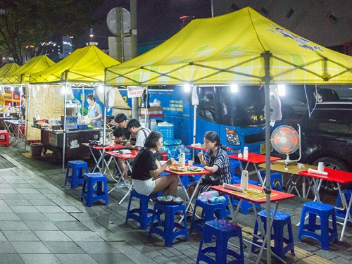 屋台料理も並び、テントの下には広々とした食事スペースも。