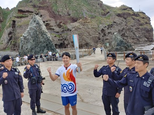 独島警備隊員のオ・ヨセフさんと同僚警備隊員らが２６日午前、慶尚北道独島で聖火リレーを終えた後、記念撮影をしている。パク・ヘリ記者