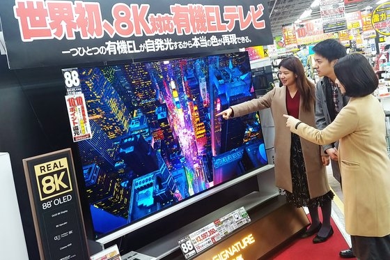 東京秋葉原にあるヨドバシカメラのショップで客が「ＬＧシグネチャー有機ＥＬ８Ｋ」の鮮明な８Ｋ解像度を体験している。［写真　ＬＧエレクトロニクス］