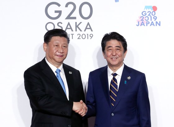 今年６月２８日、インテックス大阪で開催されたＧ２０首脳会議の公式歓迎式で、中国の習近平国家主席（左）が安倍晋三首相とあいさつしている。　［青瓦台写真記者団］