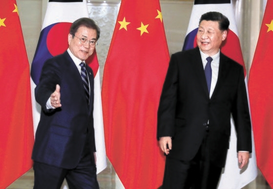 韓国の文在寅大統領（左）と中国の習近平国家主席（右）が２３日（現地時間）、中国北京人民大会堂で首脳会談のために移動している。文大統領は「米朝対話が中断されて韓半島の緊張が高まる最近の状況は、両国（韓国と中国）はもちろん、北朝鮮にも絶対に得にならない」と話した。［写真　青瓦台写真記者団］