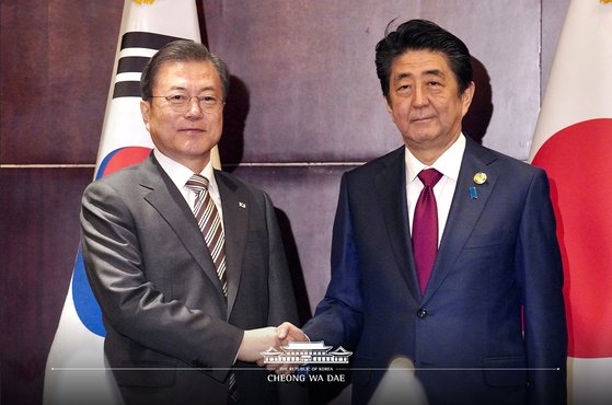 文在寅大統領と安倍首相が２４日、中国四川省成都で韓日首脳会談の前に握手している。［写真　青瓦台］