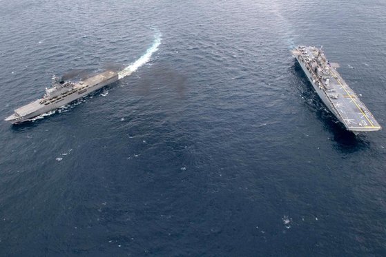 米最新型強襲揚陸艦「アメリカ」（右）と日本海上自衛隊輸送艦「くにさき」が東シナ海で共同訓練を行っている。［写真　米海軍］